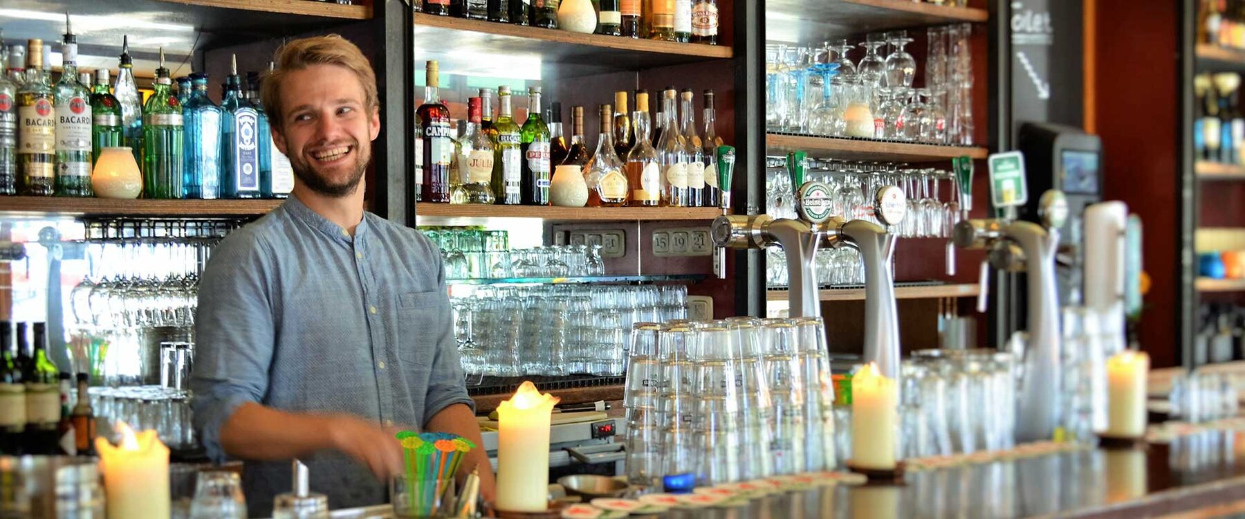 Barman achter de bar van Café Binnen Buiten