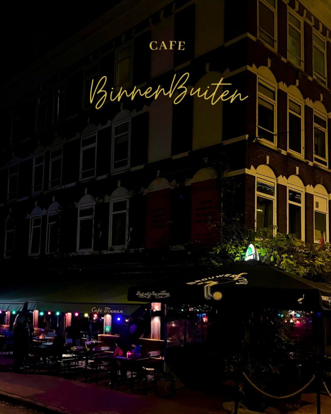 De gevel van Café Binnen Buiten 's avonds met verlicht terras