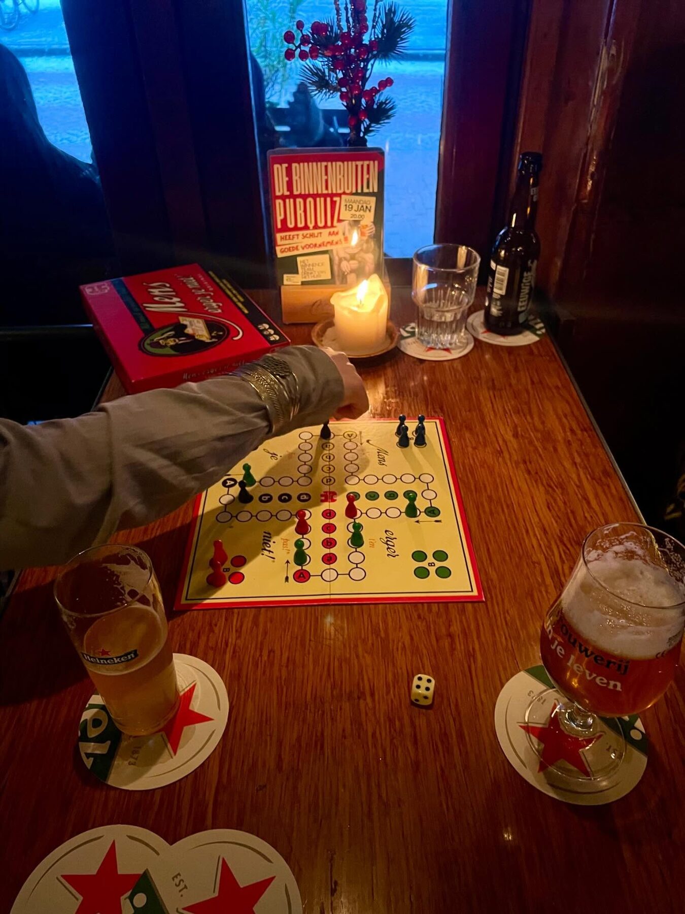 Mens-erger-je-niet op een houten cafétafel met bier