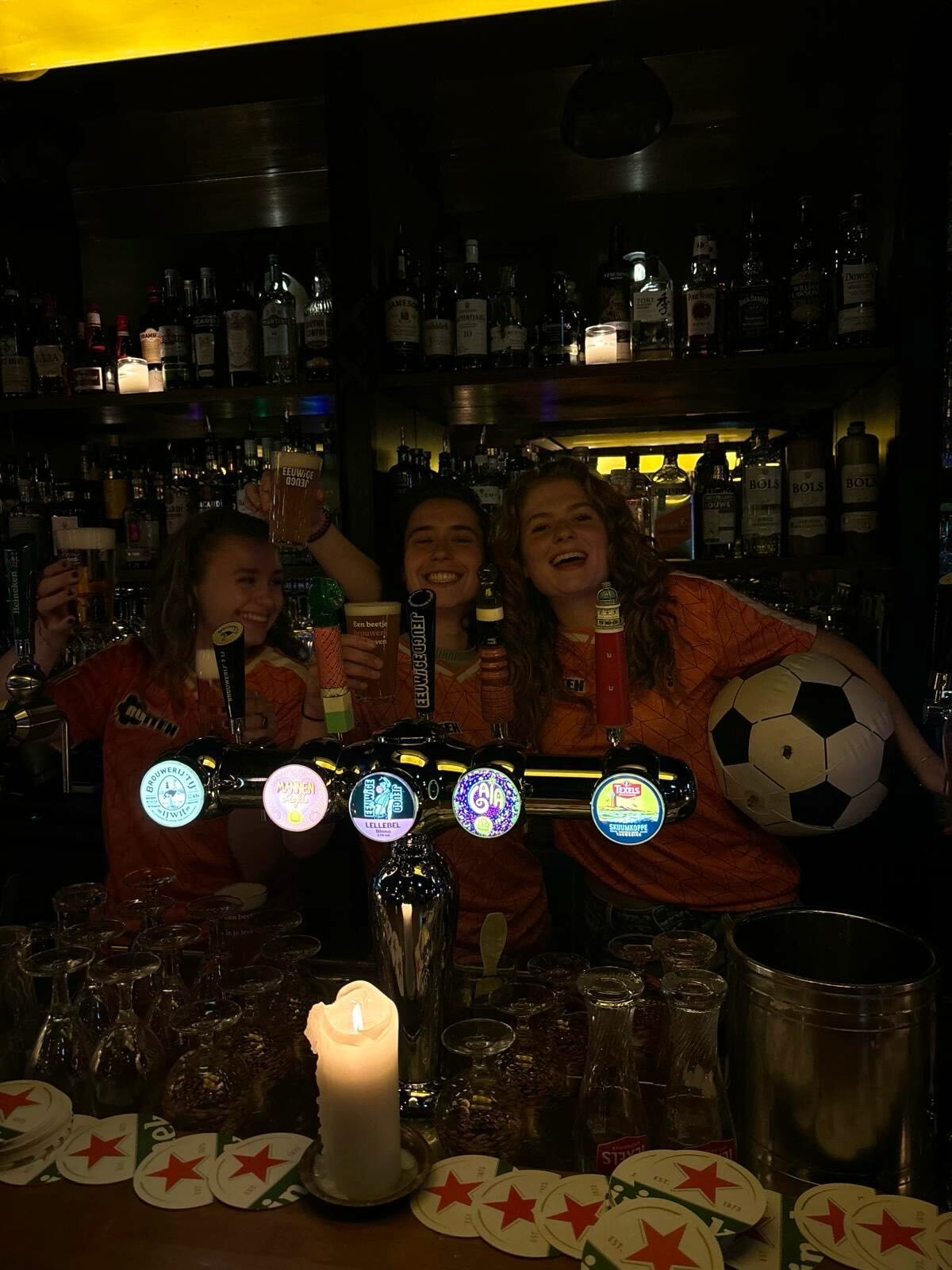 Team achter de bar in oranje met een voetbal